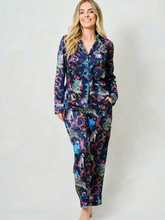 Load image into Gallery viewer, Hope & Ivy SUZANNE Zebra Pyjamas – women’s satin pyjama set featuring hand-painted zebra and floral print, blue piping, button-up shirt and matching trousers. Ideal for lounging, gifting or travel.