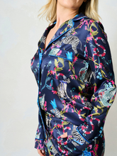 Load image into Gallery viewer, Hope & Ivy SUZANNE Zebra Pyjamas – women’s satin pyjama set featuring hand-painted zebra and floral print, blue piping, button-up shirt and matching trousers. Ideal for lounging, gifting or travel.