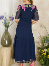 Load image into Gallery viewer, Hope & Ivy Grace navy embellished wrap dress with flutter sleeves, tie waist and pink/purple wisteria detail; maxi length approx. 143 cm.