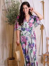 Load image into Gallery viewer, Hope & Ivy Priscilla Floral Dress – sustainable sage-green floral maxi wrap dress with flutter sleeves and tie waist. Made from 100% recycled materials. Perfect for weddings and summer occasions.