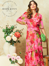 Load image into Gallery viewer, Hope & Ivy Roxanne Floral Dress – sustainable pink floral maxi wrap dress with flutter sleeves and tie waist. Hand-painted red floral design made from 100% recycled materials. Perfect for weddings and summer occasions.