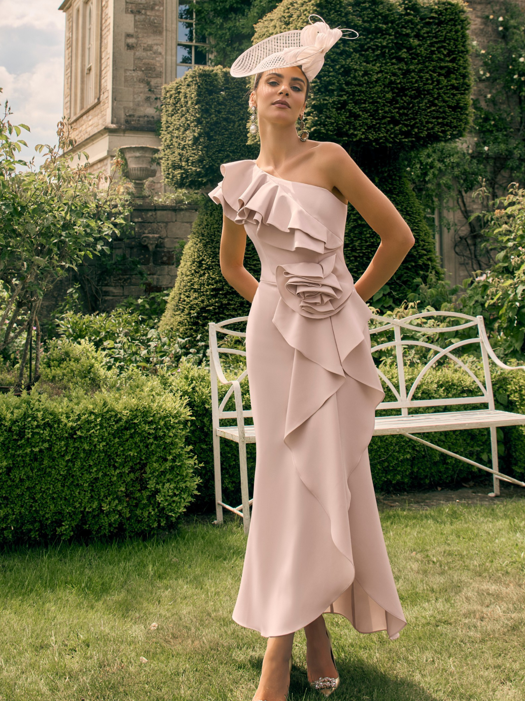 Veni Infantino 992737 Almond Dress in crepe with one-shoulder ruffle detailing, floral waist appliqué and flowing midi skirt. Elegant occasion dress for weddings and special events.