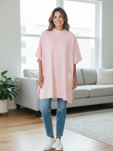Cape by Alice Collins featuring button detailing on the shoulder, patch pockets, and a high neckline – soft lightweight knit ideal for layering and casual everyday wear.