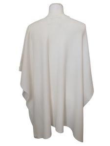 Cape by Alice Collins featuring button detailing on the shoulder, patch pockets, and a high neckline – soft lightweight knit ideal for layering and casual everyday wear.