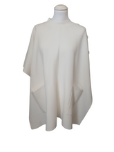 Load image into Gallery viewer, Cape by Alice Collins featuring button detailing on the shoulder, patch pockets, and a high neckline – soft lightweight knit ideal for layering and casual everyday wear.
