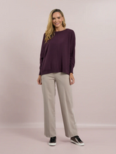 Load image into Gallery viewer, Deck by Decollage tapered sand trousers with a wide waistband, soft pleats, and ankle-length fit. Designed for a sleek, flattering silhouette in a neutral tone-perfect for smart-casual styling.
