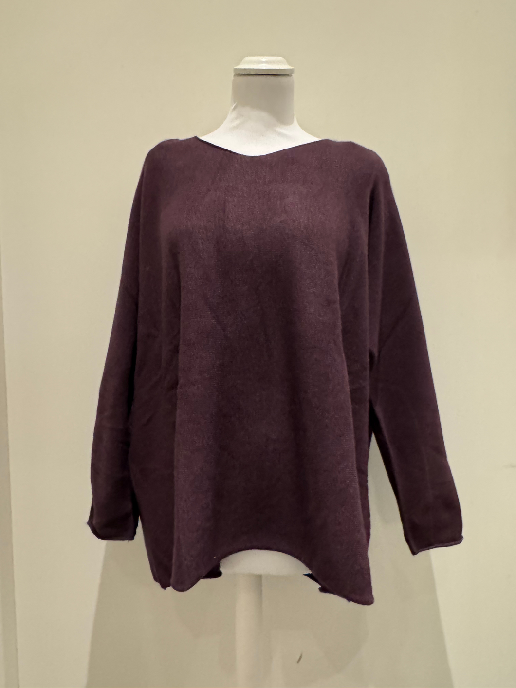 The knit top features a relaxed silhouette, soft texture, and full-length sleeves in a deep mulberry hue, designed for effortless layering and cosy everyday wear.