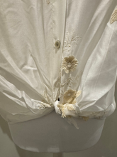 Load image into Gallery viewer, White sheer tie-front blouse with floral embroidery and 3/4 sleeves from Deck by Decollage, styled with dark trousers for a smart casual look.

