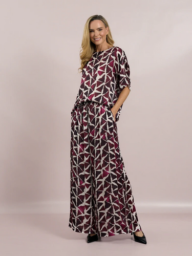 Deck by Decollage wide-leg trousers with an abstract berry and ivory print, featuring an elasticated waistband and fluid silhouette-designed for bold, stylish comfort.