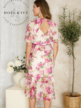 Load image into Gallery viewer, Hope &amp; Ivy Alessia Floral V-Neck Midi Tea Dress – sustainable cream floral midi dress with peplum waist, tiered ruffle skirt, and ladder trim. Made from 100% recycled materials. Perfect for garden parties and summer events.
