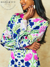 Load image into Gallery viewer, Hope &amp; Ivy Caroline White Floral Maxi Dress – sustainable women’s satin floral print dress with blouson sleeves, frilled hem and tie-back detail. Ideal for weddings, garden parties and summer occasions.
