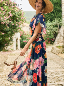 Hope & Ivy Jean Floral Dress – sustainable cowl-neck maxi dress with waterfall sleeves and hand-designed poppy print in red, pink, and orange. Made from 100% recycled materials. Perfect for weddings and summer occasions.