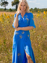 Load image into Gallery viewer, Hope &amp; Ivy Mallory Blue Embellished Wrap Dress – elegant blue embellished maxi wrap dress with silver and gold detailing, flutter sleeves, and tie waist. Perfect for weddings and evening occasions.
