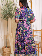 Load image into Gallery viewer, Hope &amp; Ivy Nesta Floral Wrap Dress – sustainable navy floral chiffon wrap dress with flutter sleeves and tie waist. Made from 100% recycled materials. Perfect for weddings, garden parties, and summer occasions.
