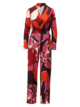 Load image into Gallery viewer, Full-length women’s printed jumpsuit by K Design featuring bold red, pink and purple abstract floral print, wrap-front neckline, long sleeves and belted waist - perfect for smart casual and evening wear styling.
