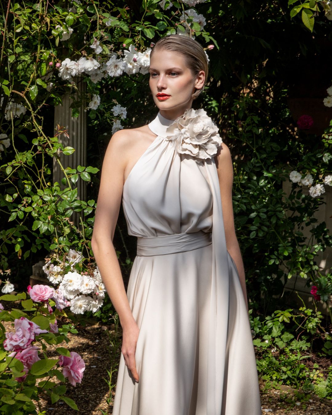 Maisonel ME3004 Oyster Dress – women’s halter neck satin occasion dress in elegant oyster tone with floral applique and asymmetric hem, perfect for weddings and formal events.