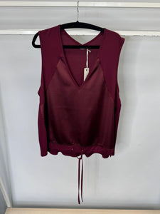 Maroon sleeveless top on a hanger against a white background