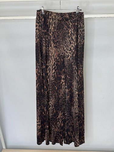 Leopard print trousers hanging on a rack against a white background