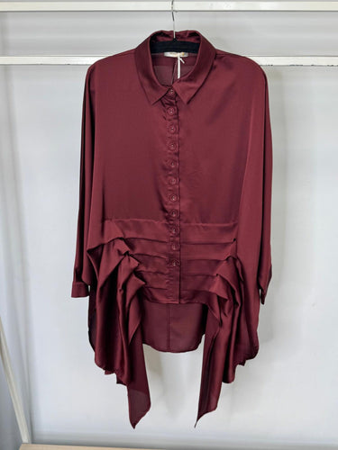 Maroon shirt with layered design on a hanger against a white background