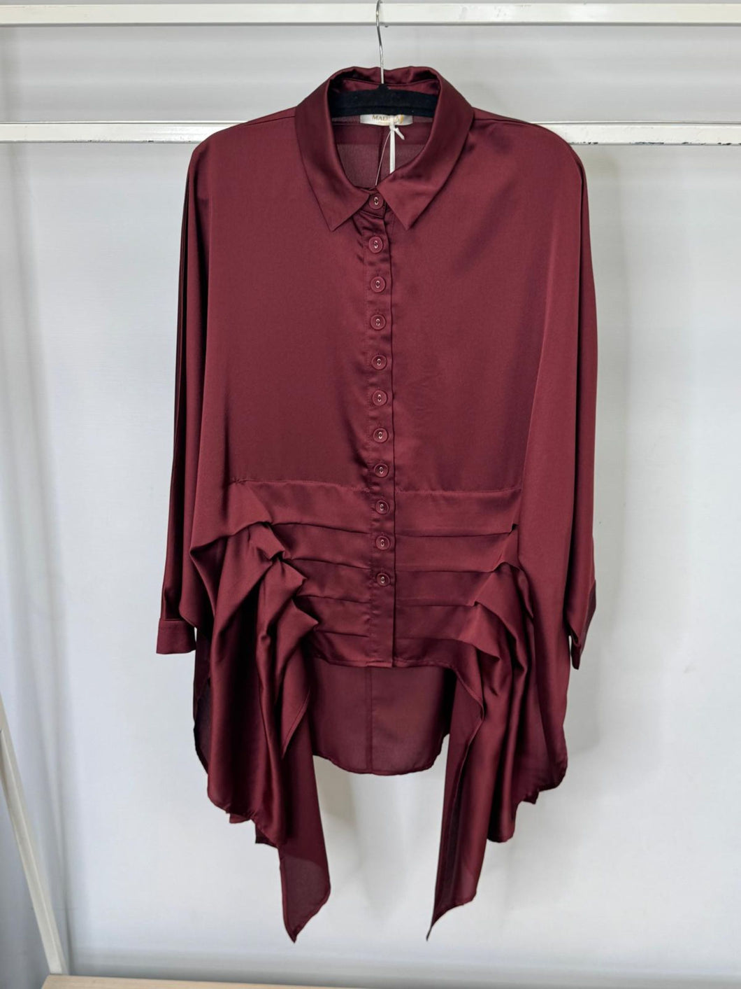 Maroon shirt with layered design on a hanger against a white background