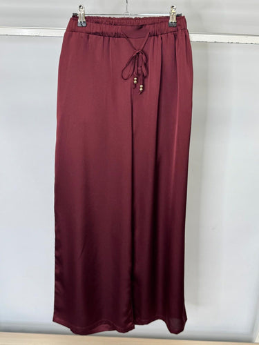 Maroon trousers with drawstring waist on a white background