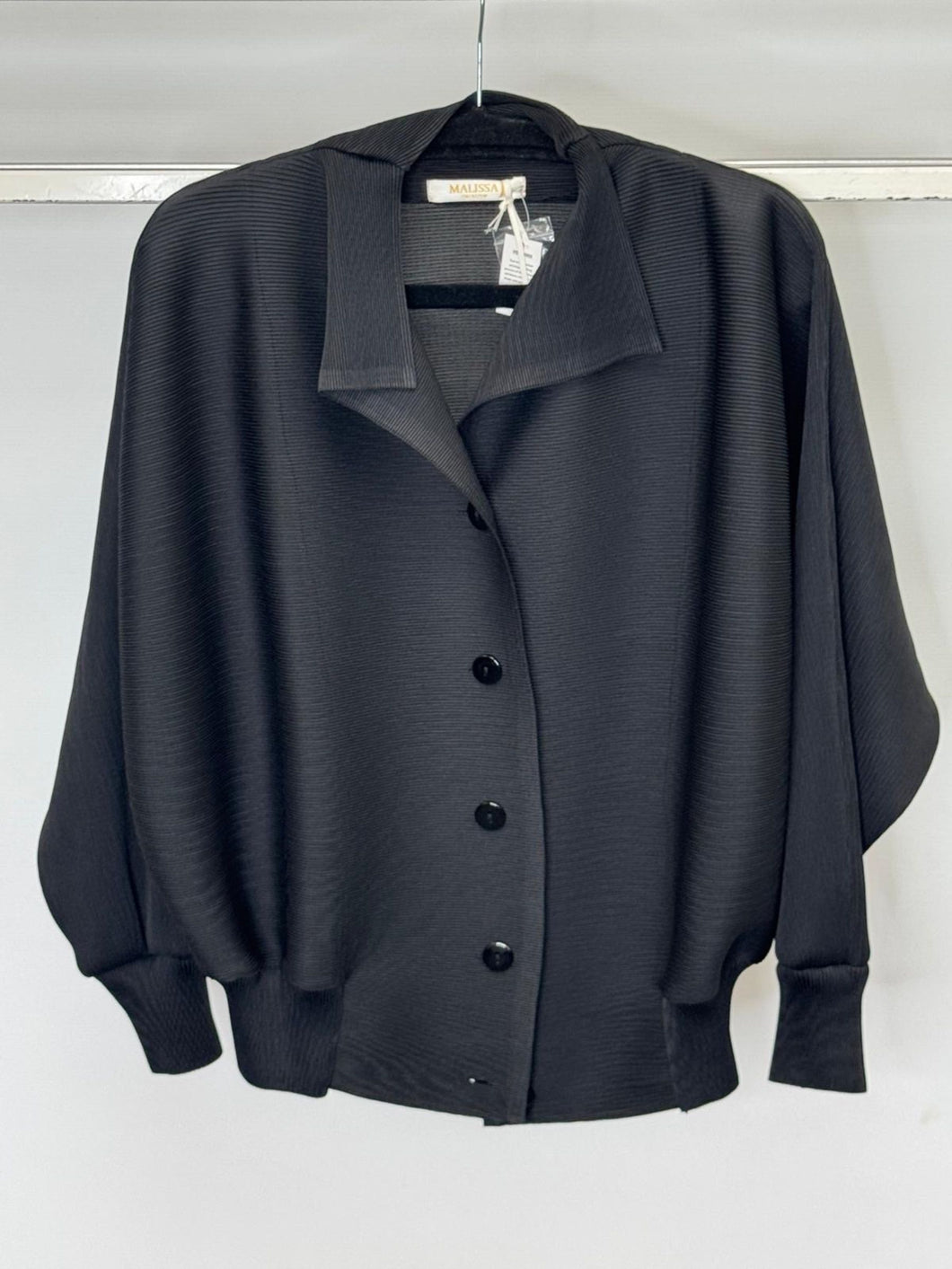 Black button-up shirt on a hanger against a white background