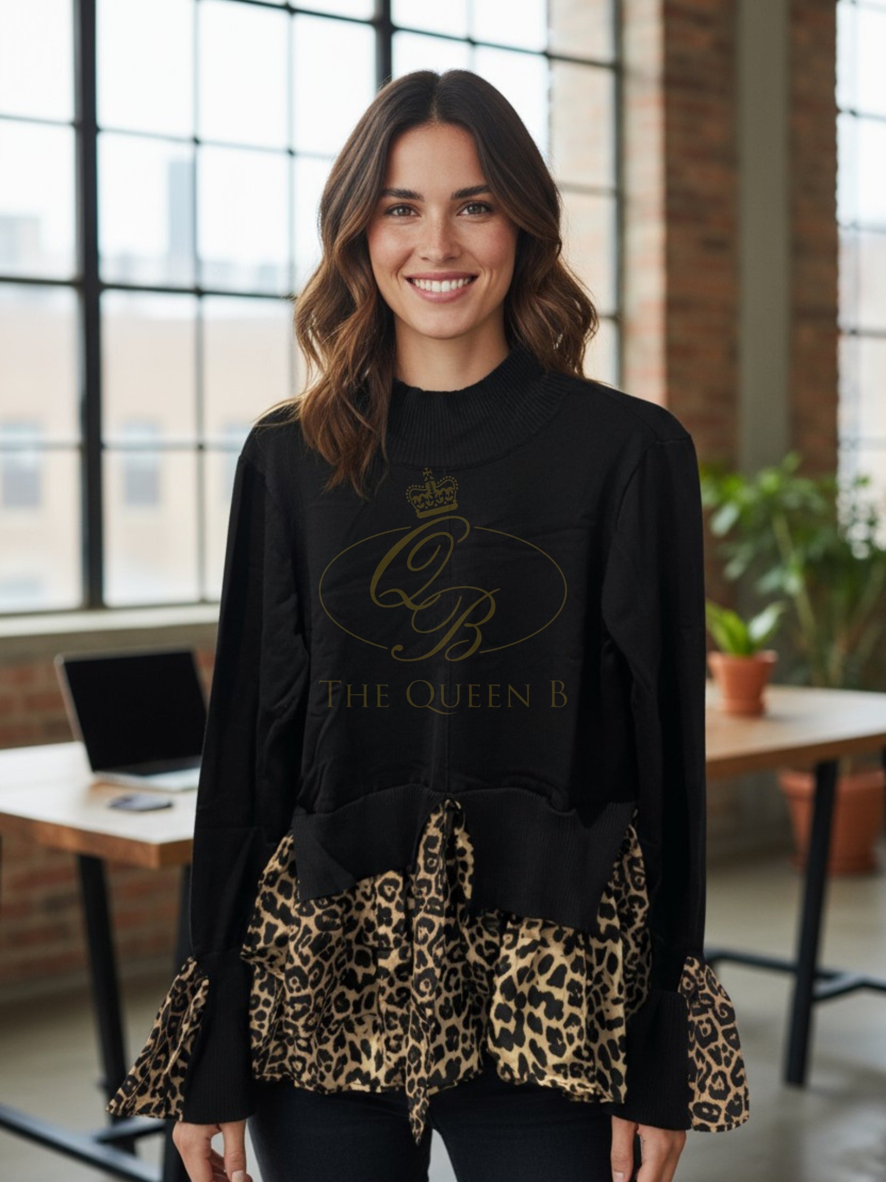 Black knit top with leopard print hem and cuff inserts, featuring a ribbed neckline and long sleeves.