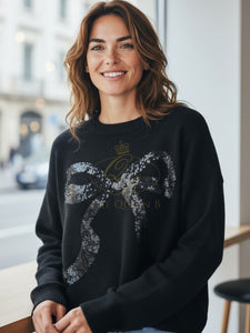Black knit jumper with sequin bow embellishment, crew neckline, and ribbed hem from Paramour.