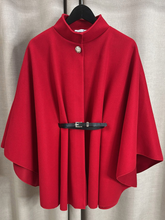 Load image into Gallery viewer, The QBAW25 RR Red Carrie Cape features a structured silhouette with wide sleeves, a high neckline and elegant gold button detailing. Finished with a detachable belt for a flattering fit, this chic cape blends timeless tailoring with modern sophistication - perfect for layering over seasonal outfits.
